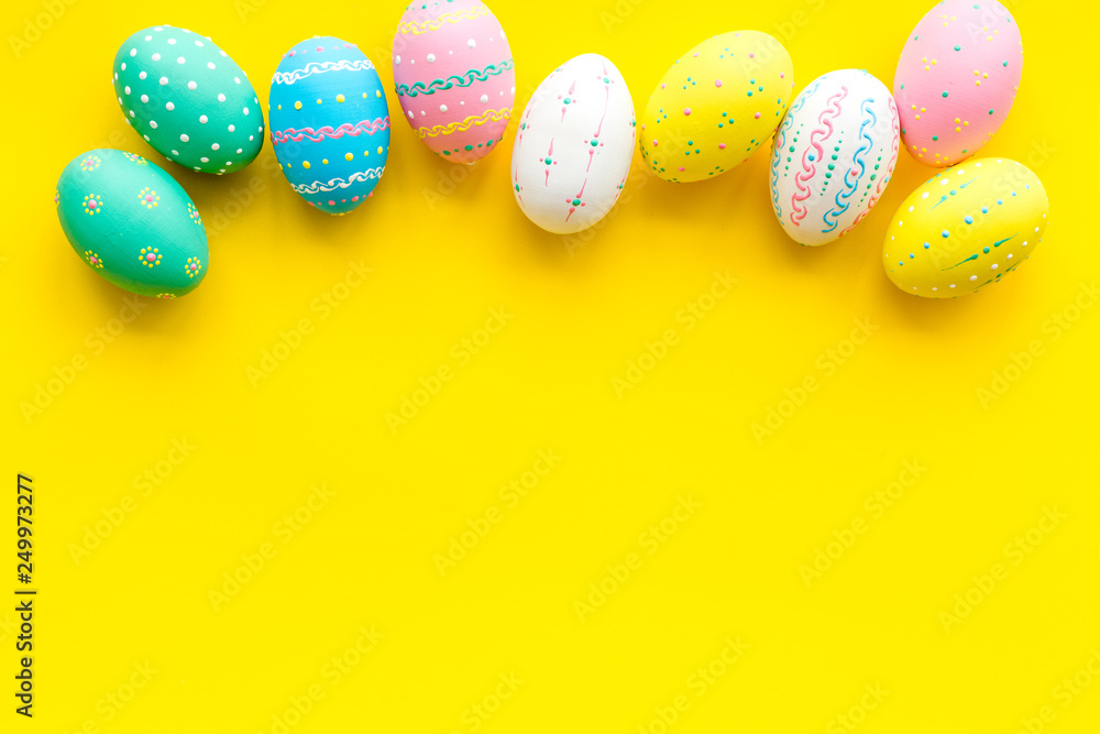Easter composition. Decorated pastel Easter eggs on yellow background