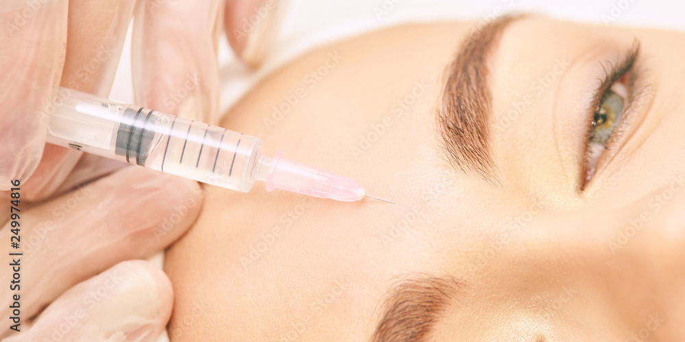 Forehead woman surgery. Anti wrinkle filler. Cosmetology injection. Face skin rejuvenation. Doctor injecting collagen acid Forehead woman surgery. Anti wrinkle filler. Cosmetology injection. Face skin rejuvenation. Doctor injecting collagen acid