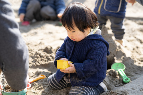 砂場で砂遊びする子供 © polkadot