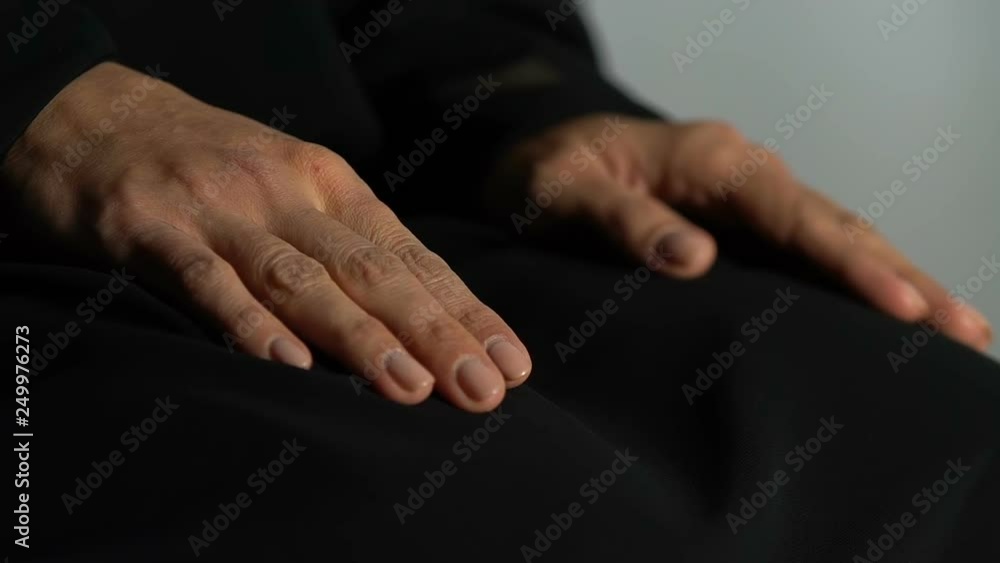 Mourning widow praying in church, hands close-up, pain of loss, faith and hope Mourning widow praying in church, hands close-up, pain of loss, faith and hope