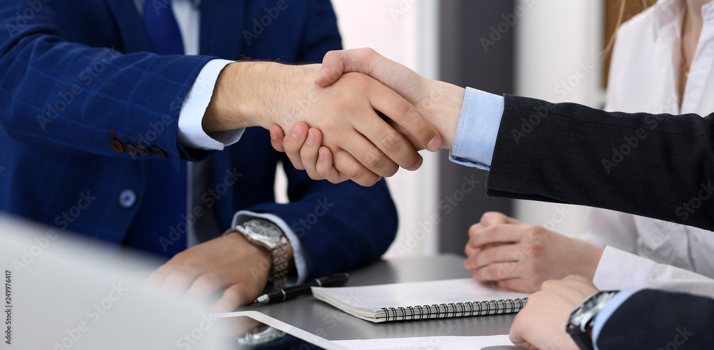 Business people shaking hands, finishing up a papers signing. Meeting, agreement and lawyer consulting concept Business people shaking hands, finishing up a papers signing. Meeting, agreement and lawyer consulting concept