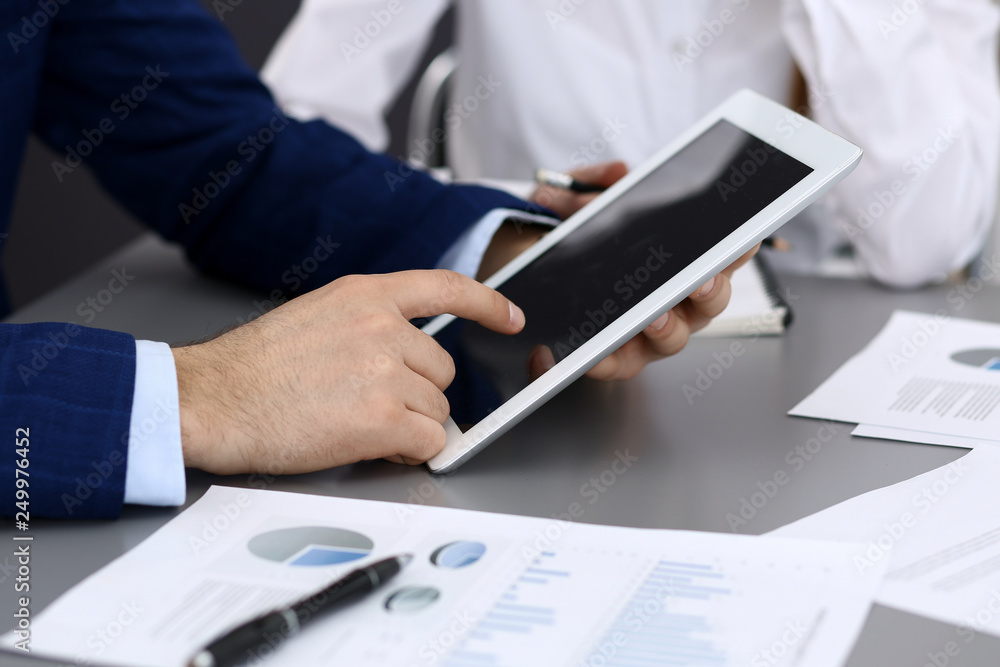 Businessman using tablet at meeting, closeup of hands. Business operations concept Businessman using tablet at meeting, closeup of hands. Business operations concept