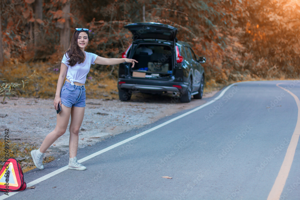 Young girl is waving car for help her broken car
