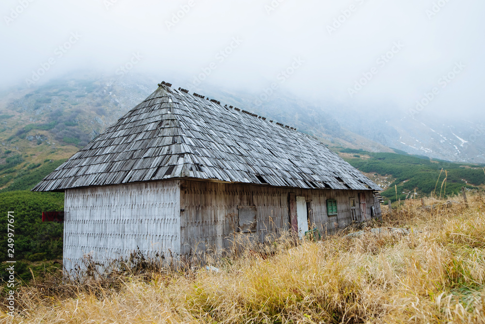 An old wooden house in the middle of the mountains in the autumn period