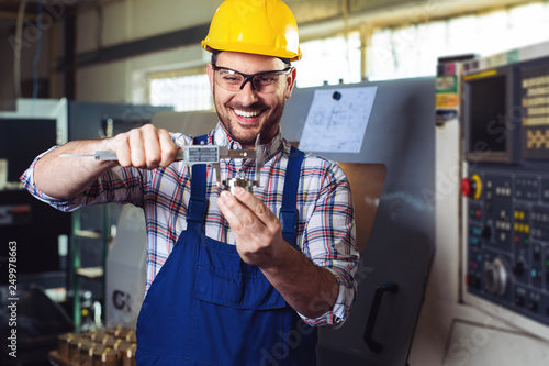 Industrial worker inspector measuring detail with Vernier Caliper