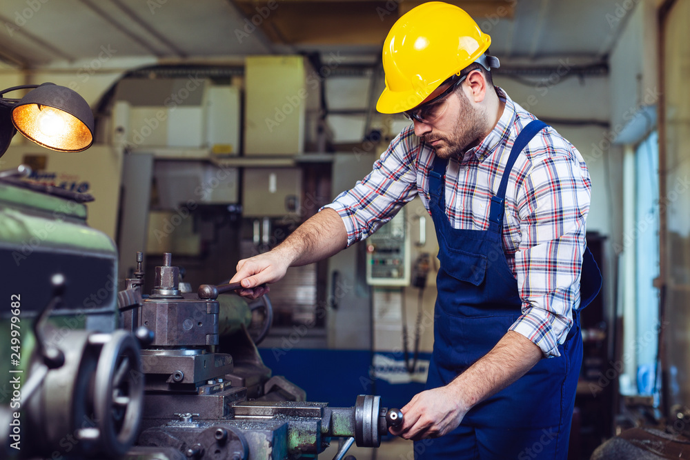 Turner worker is working on a lathe machine in a factory Turner worker is working on a lathe machine in a factory