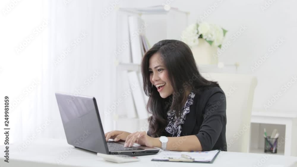 Excited businesswoman very happy while using laptop at her office Excited businesswoman very happy while using laptop at her office