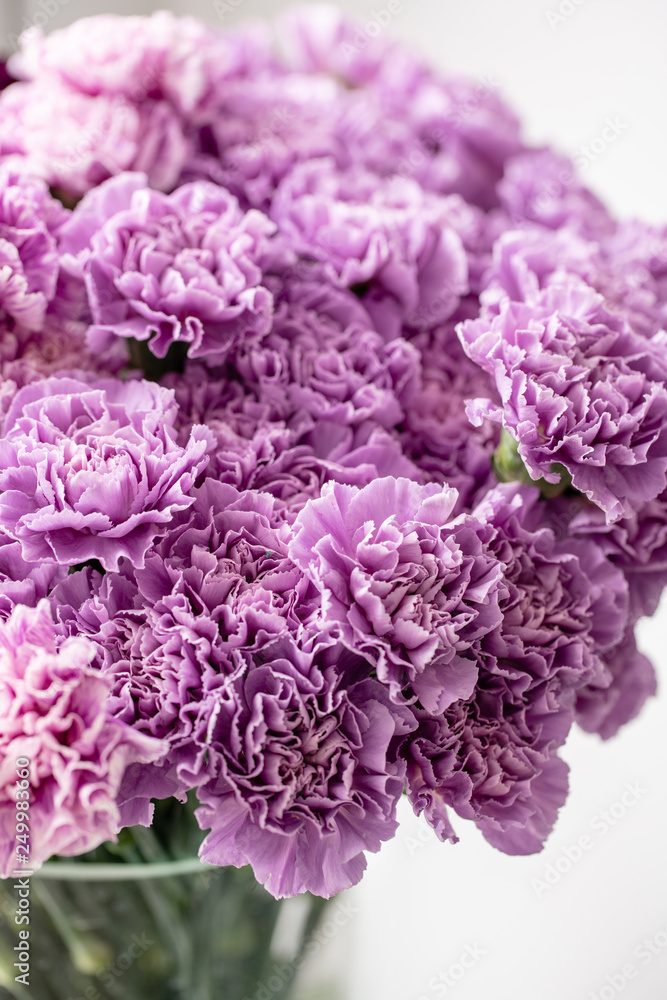 beautiful carnations flowers in a vase on a table . Bouquet of dark violet, purple and pink multicolor flower. Decoration of home. Floral texture, Wallpaper.