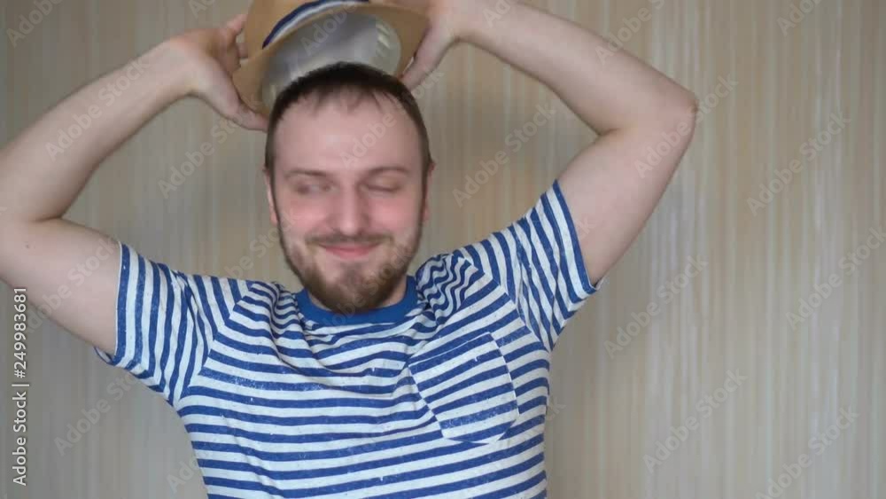 Closeup of cheerful young man in hat standing and smiling