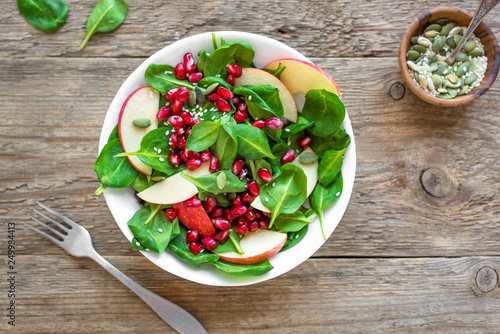 Spinach, apple salad with pomegranate seeds