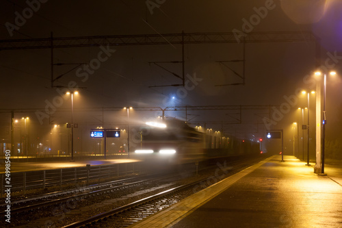 Train in motion on the station at night, long exposure photo. © Elena Noeva