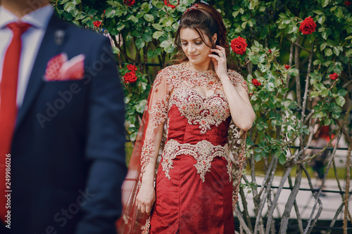 Photography Beautiful woman in a long red dress walks around the city with her husband in a