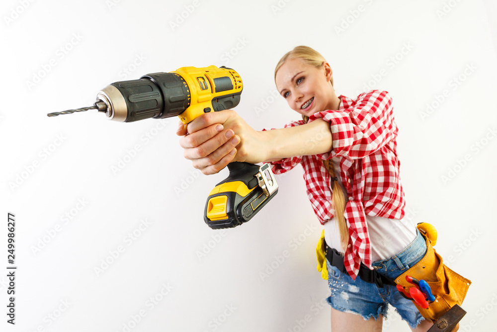 Woman using drill on wall