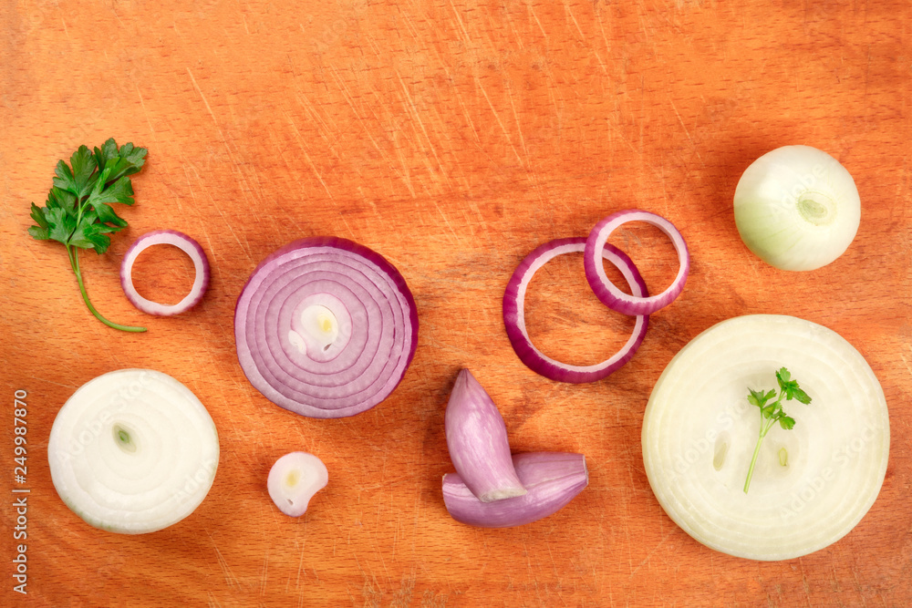 Red and white onions, shot from the top with parsley leaves on a used cutting board with copy space Red and white onions, shot from the top with parsley leaves on a used cutting board with copy space