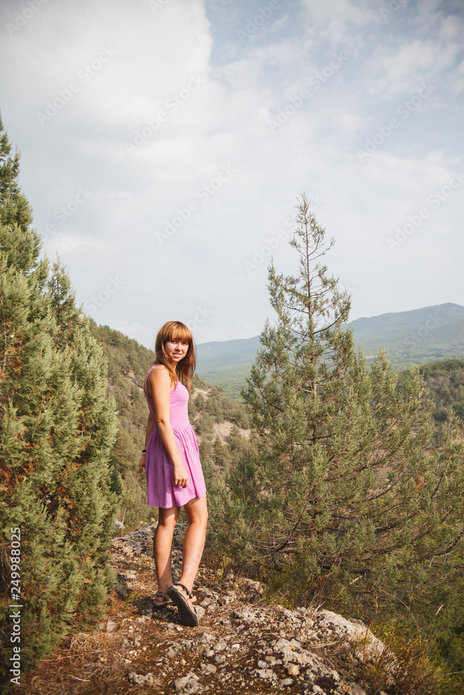 Naklejka premium The girl is sitting on a rock. Down the river runs