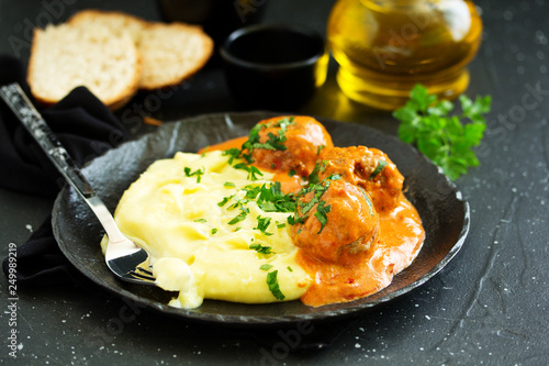 Meatballs in creamy tomato sauce with mashed potatoes.