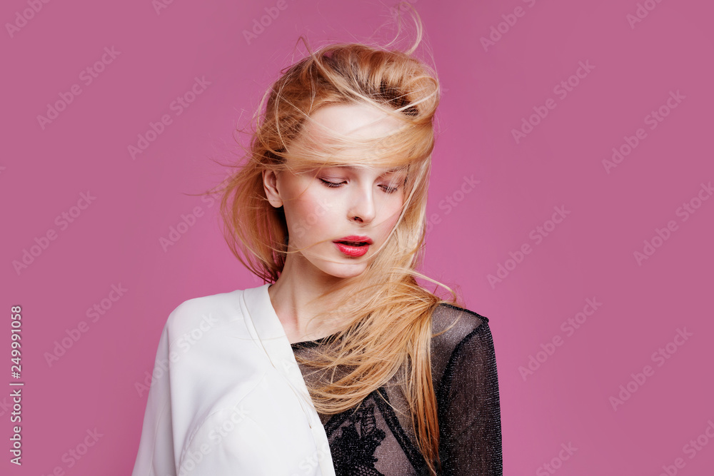 Blonde young woman in elegant body. Girl posing on a pink background. Make -up and hairstyle. Fashion photo Blonde young woman in elegant body. Girl posing on a pink background. Make -up and hairstyle. Fashion photo