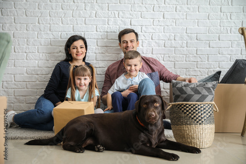 Family sitting on floor nea...