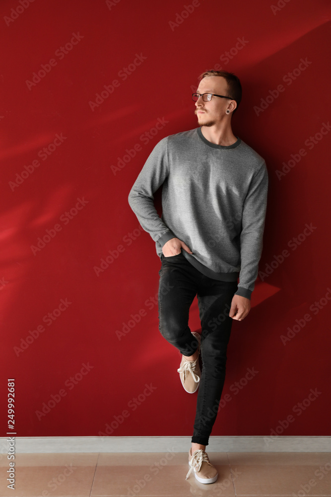 Portrait of handsome young man near color wall
