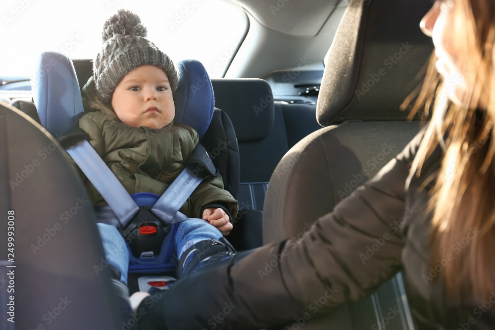 Woman driving car with her son buckled in baby seat