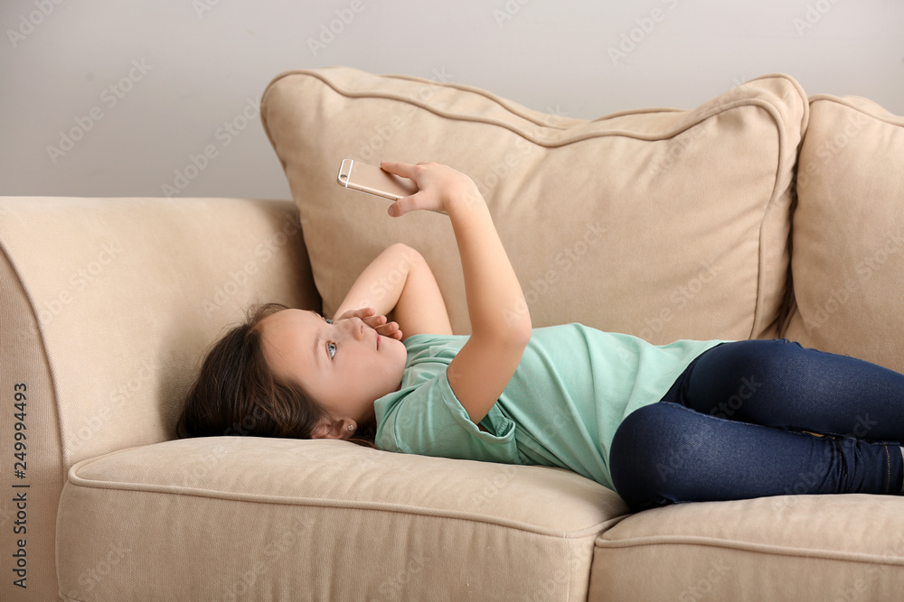 Cute little girl with mobile phone at home Cute little girl with mobile phone at home