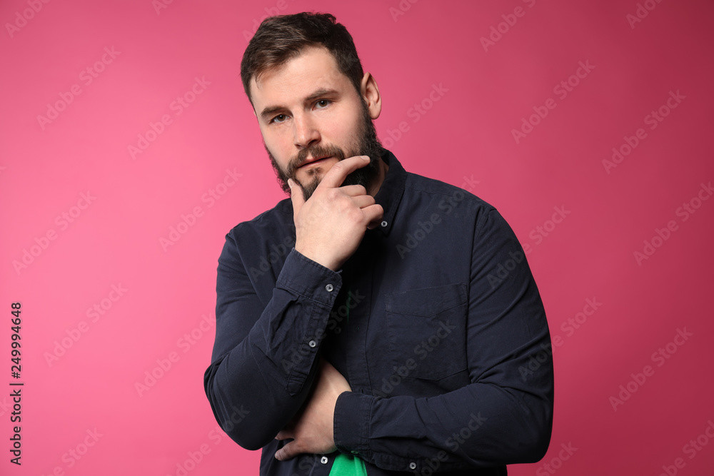 Bearded man in casual clothes on color background