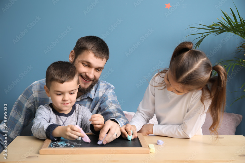 Young father with his children drawing at home Young father with his children drawing at home