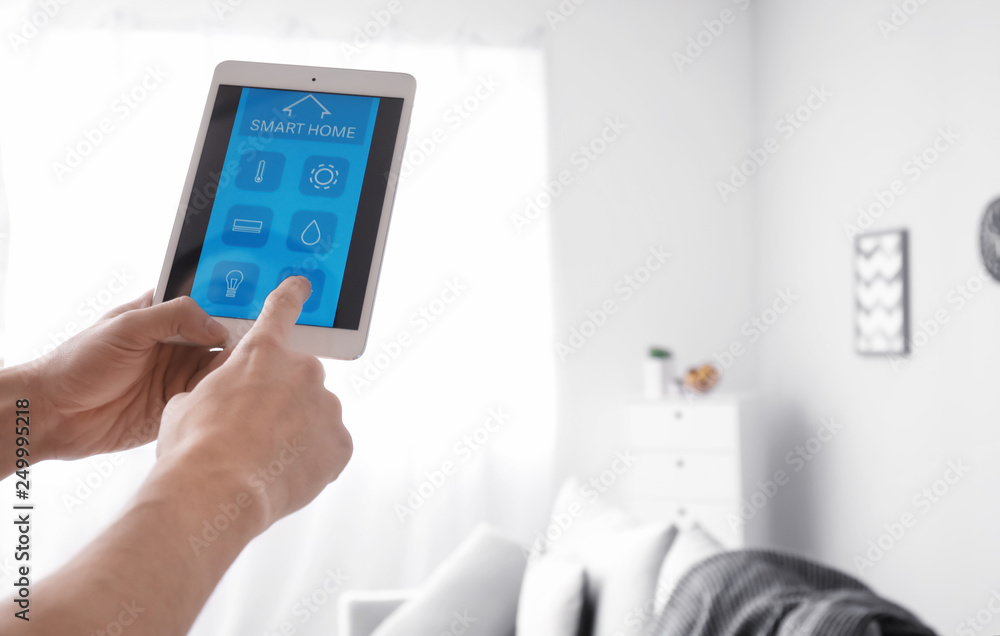Young man using application of smart home automation Young man using application of smart home automation