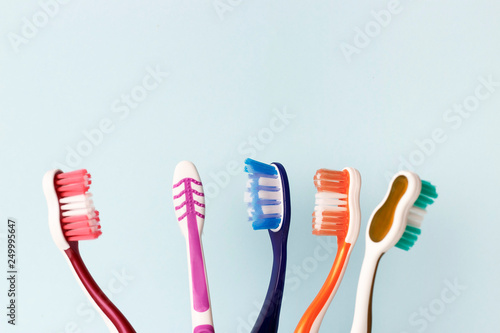 Multi-colored toothbrushes on a blue background  copy space