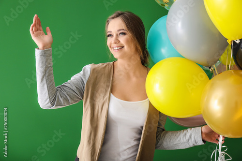 Beautiful young woman with balloons on color background © Pixel-Shot