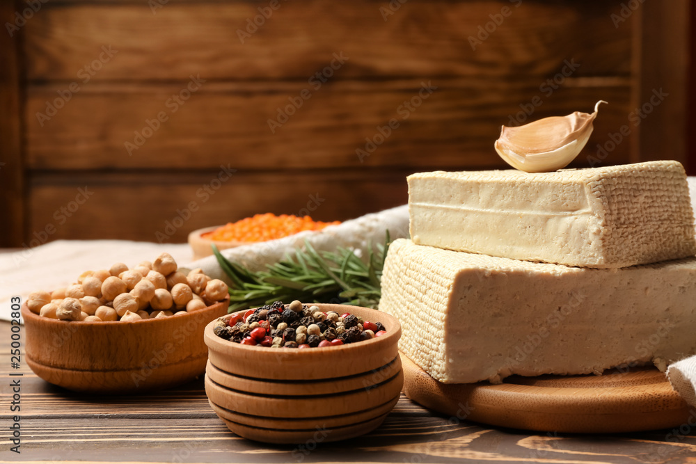 Tasty tofu cheese with spices on wooden background