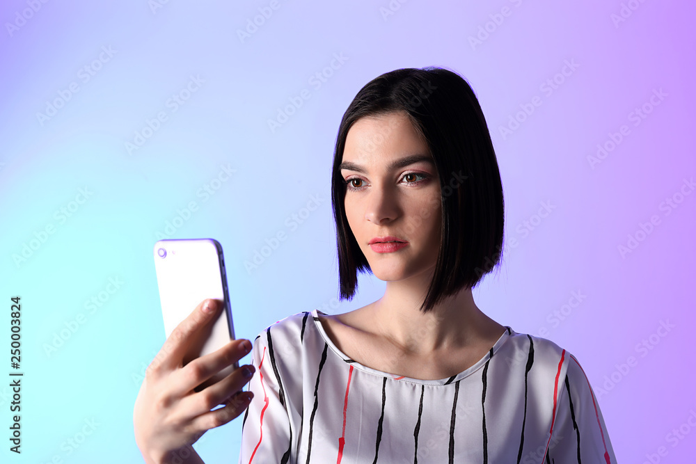 Portrait of young woman with mobile phone on color background Portrait of young woman with mobile phone on color background