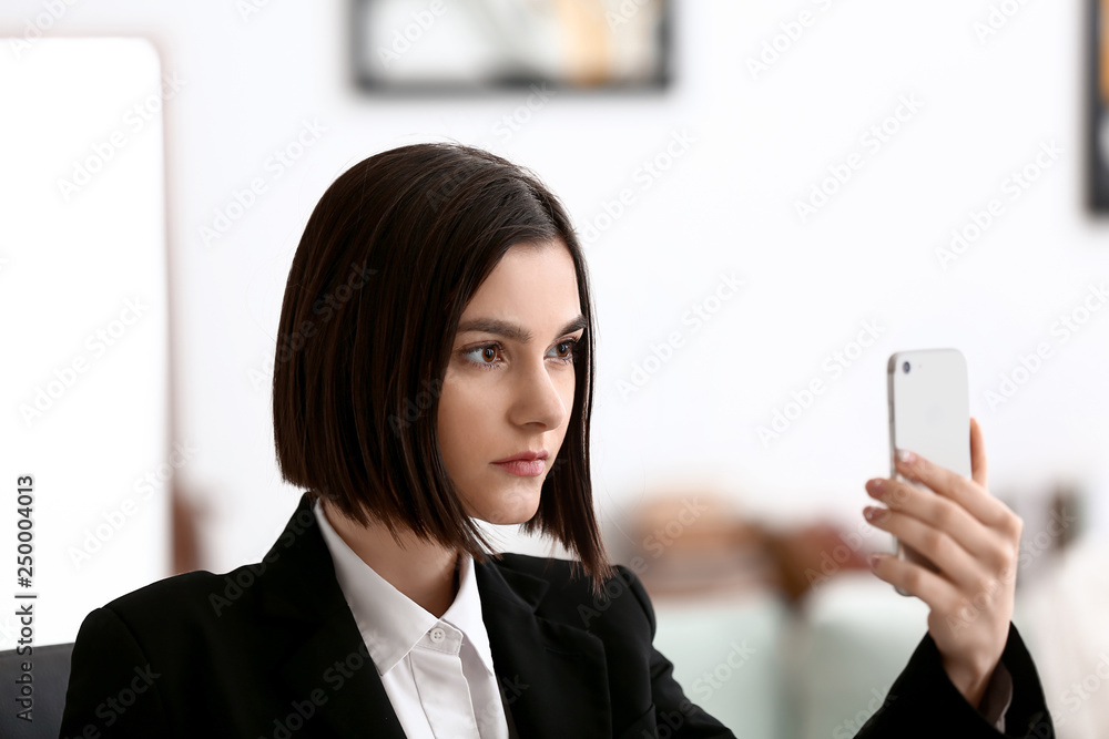 Young woman taking selfie with mobile phone in office Young woman taking selfie with mobile phone in office