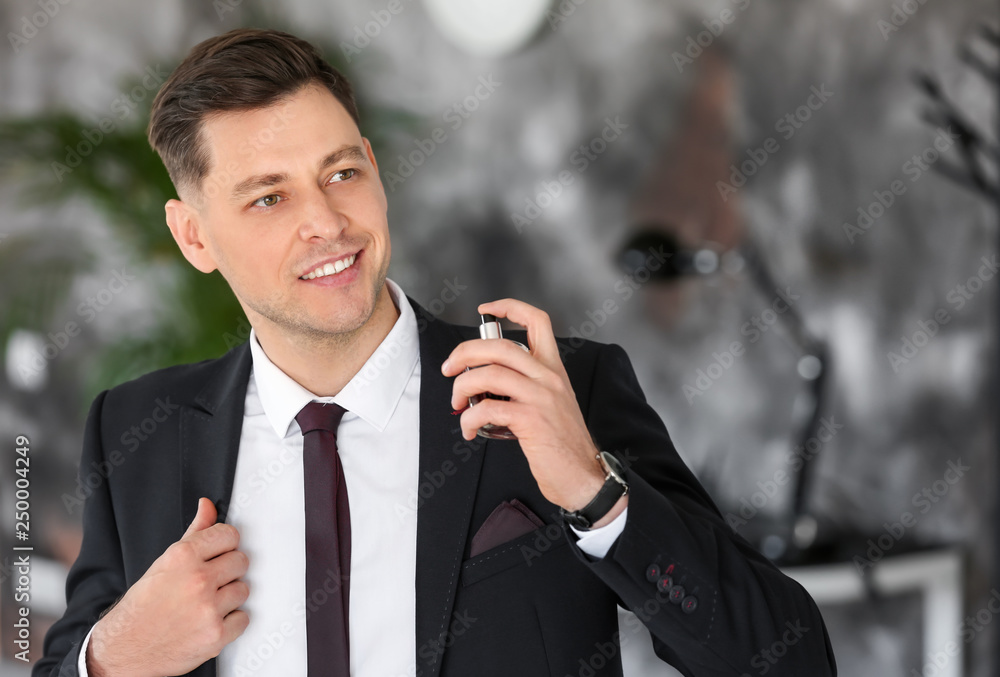 Handsome businessman with bottle of perfume indoors Handsome businessman with bottle of perfume indoors