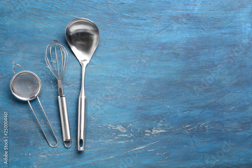 Stainless steel kitchen utensils on wooden table