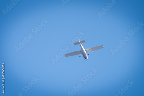 A small white plane flying in the sky