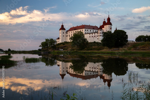 Evening shot of Lacko castle with reflection in the mirror like water of lake Vanern, Lidköping, Sweden