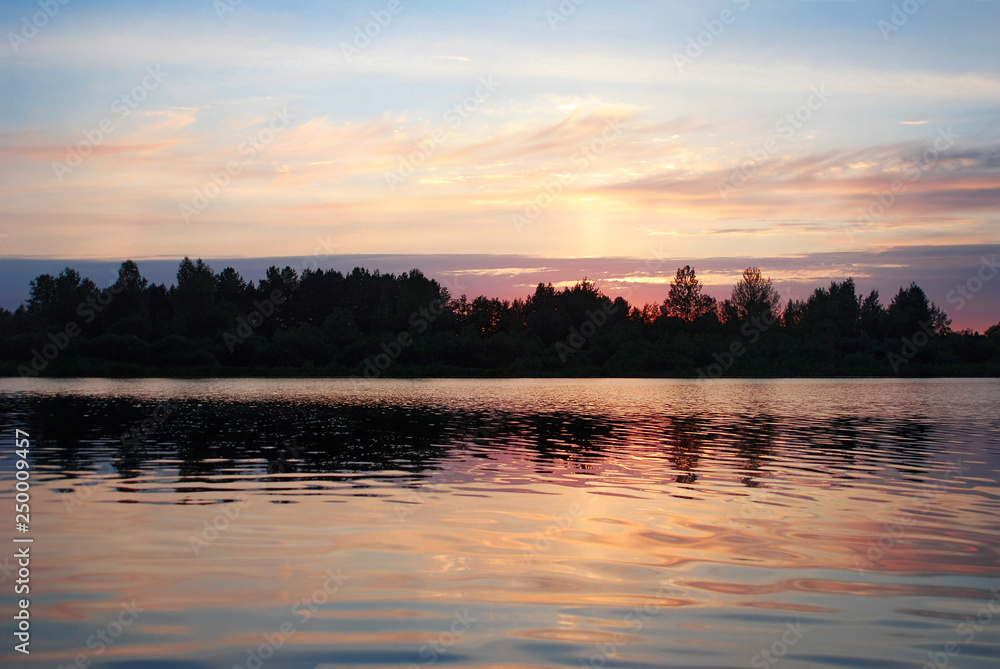 Reflection Of Sky, Clouds And Trees In Lake during sunset in the background Reflection Of Sky, Clouds And Trees In Lake during sunset in the background