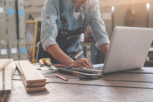 Carpenter working with equipment on wooden table in carpentry shop. woman works in a carpentry shop. photo