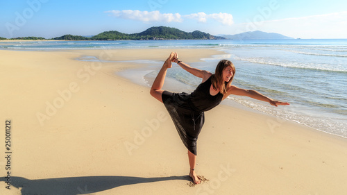 yoga on the beach  young girl in black  early morning  fog