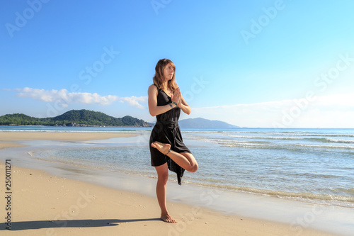 yoga on the beach, young girl in black, early morning, fog