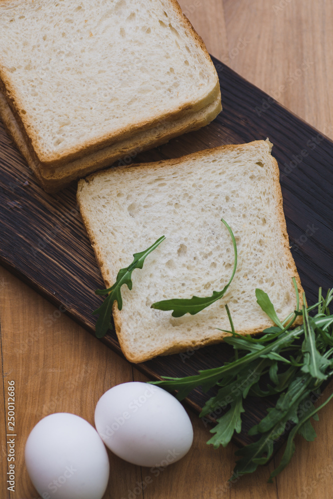 sandwich with egg and arugula on a plate is on the table sandwich with egg and arugula on a plate is on the table
