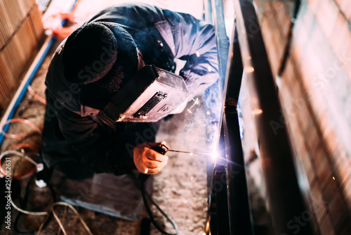 Caucasian male worker welding metal, steel structure