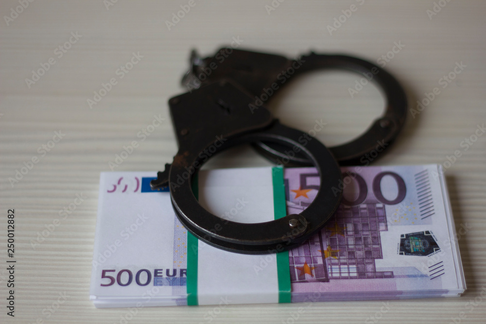 handcuffs and money on the table handcuffs and money on the table
