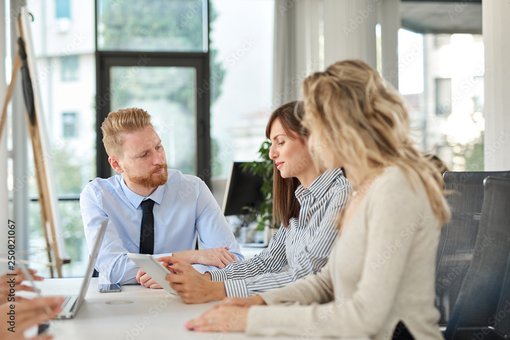 Fototapeta premium Small group of business people sitting at table and having meeting. Multi cultural group.