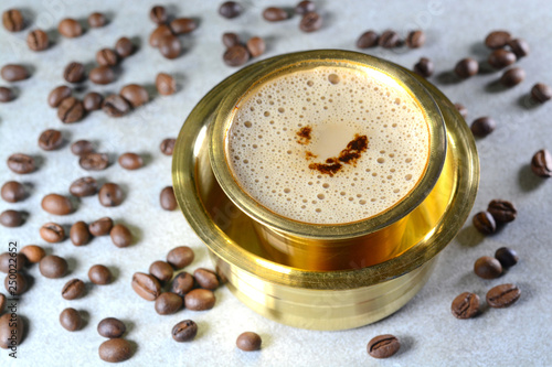 Indian Filter Coffee served in brass cup and saucer. photo