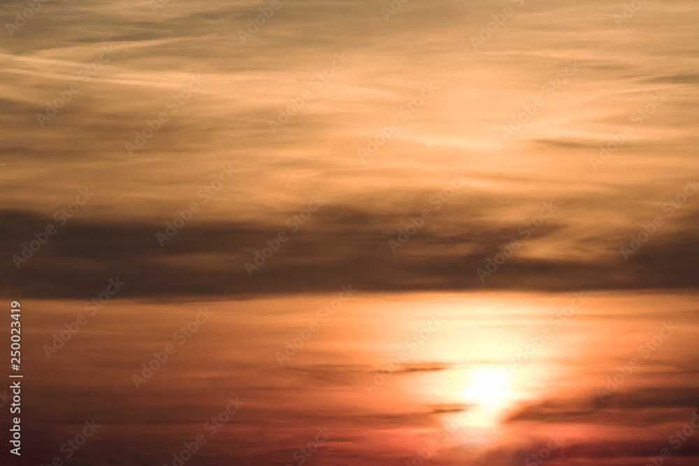 Clouds colored in orange, yellow and red at sunset.