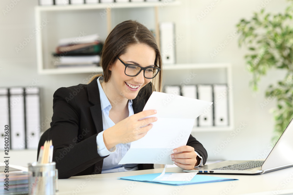 Happy office worker reading a letter Happy office worker reading a letter