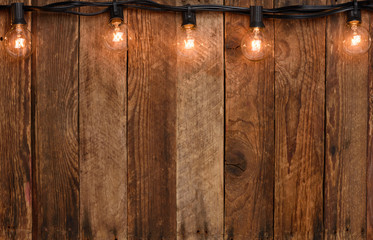 Vintage garland string lights on old wooden wall border with copy space