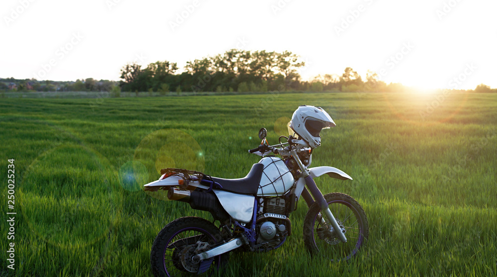 Obraz premium enduro off road Motorcycle on green grass hill landscape pine forest sunset